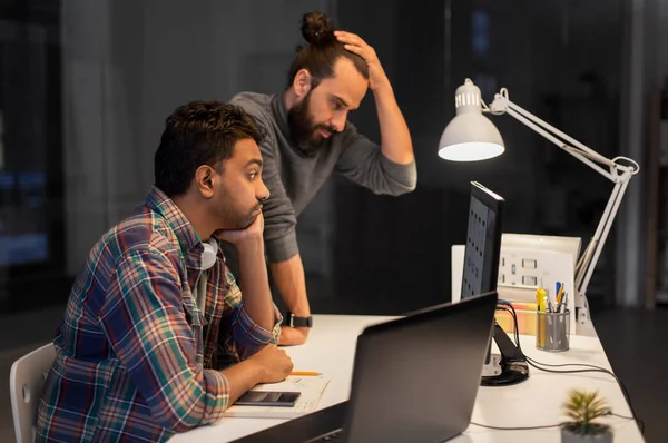 Creatieve team met computer werkt laat op kantoor — Stockfoto