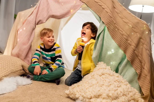 Niños felices con la luz de la antorcha en la tienda de los niños en casa —  Fotos de Stock