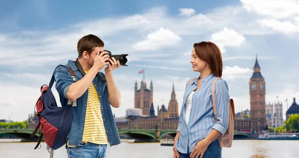 Happy couple of tourists with backpacks and camera — Stok fotoğraf