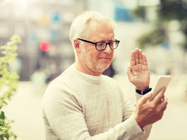 Senior man having video call on smartphone in city — Stock Photo, Image