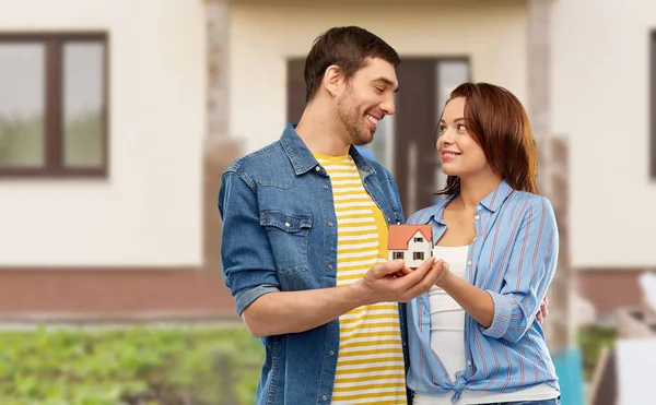 Sorrindo casal segurando modelo de casa — Fotografia de Stock