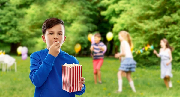 Мальчик ест попкорн на дне рождения — стоковое фото