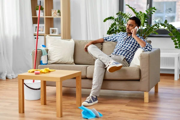 Man belt op de smartphone na het schoonmaken van het huis — Stockfoto