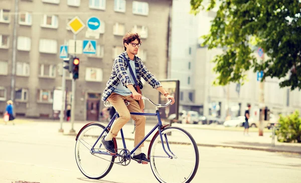 Mladý hipster muž s taškou na koni pevné kolo — Stock fotografie