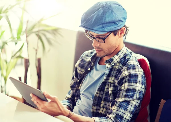 Homem com tablet pc sentado na mesa de café — Fotografia de Stock