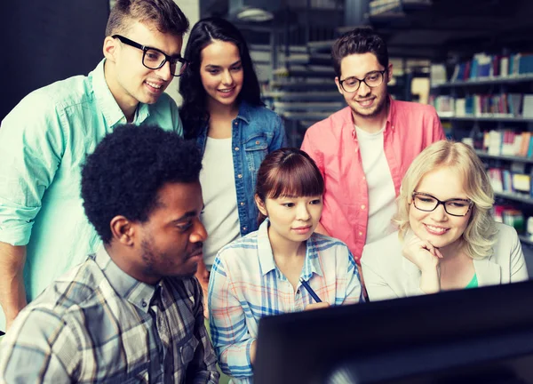 Internationella studenter med datorer på biblioteket — Stockfoto