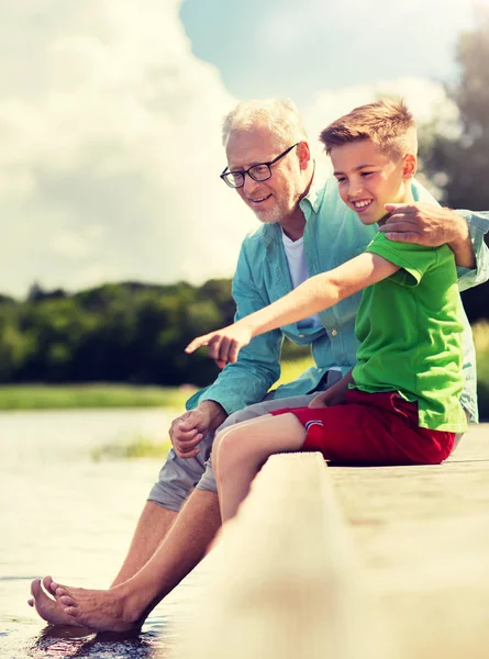 Grandfather and grandson sitting on river berth — Stock Photo, Image