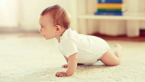 Pequeno bebê em fralda rastejando no chão em casa — Fotografia de Stock