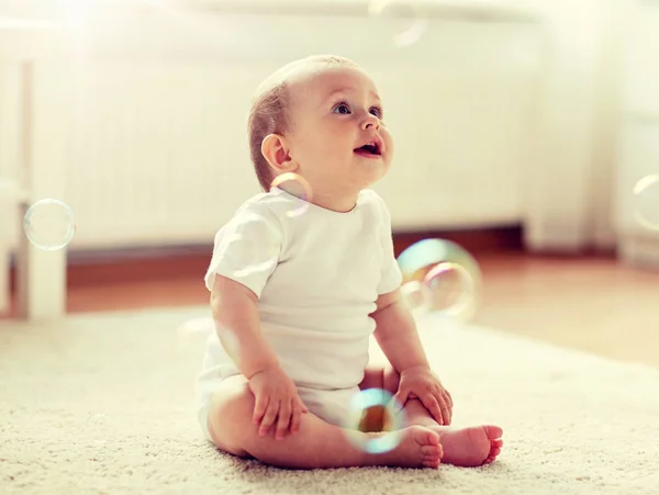 Счастливый ребенок с мыльными пузырями дома — стоковое фото