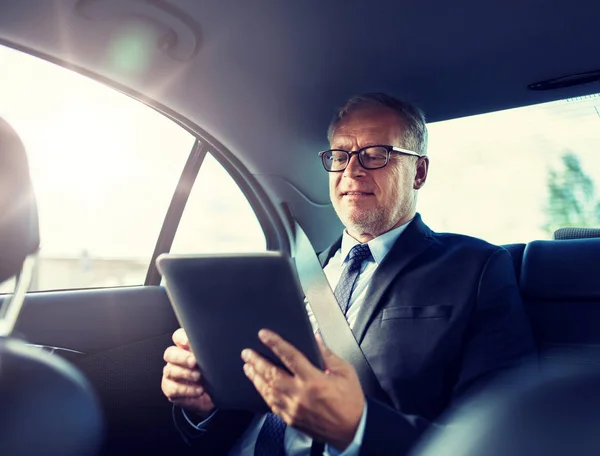 Hombre de negocios senior con la PC tableta de conducción en el coche —  Fotos de Stock