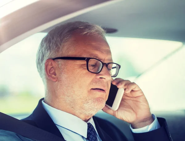 Senior affärsman ringer på smartphone i bilen — Stockfoto