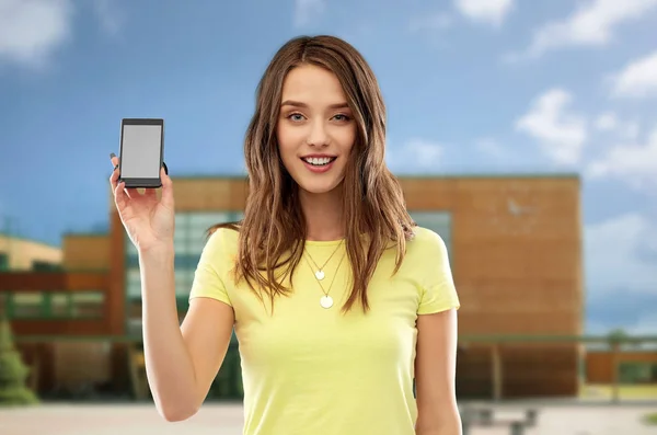 Teenage girl holding smartphone over school — Stock Photo, Image