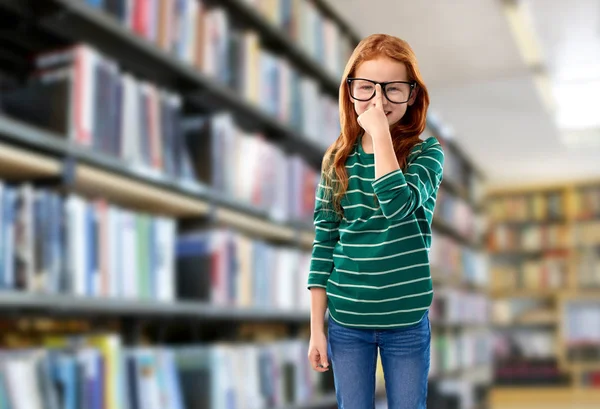 Bonito vermelho cabelos estudante menina em óculos na biblioteca — Fotografia de Stock