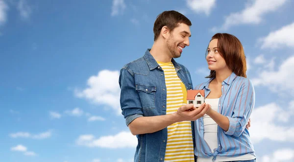 Sonriente pareja holding casa modelo — Foto de Stock