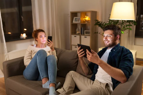 Pareja con tablet y smartphone en casa — Foto de Stock