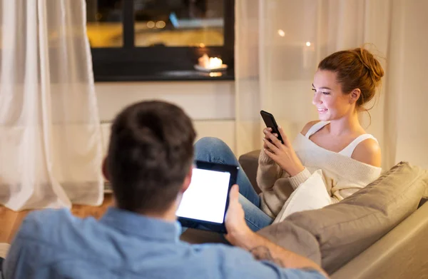 Casal com tablet computador e smartphone em casa — Fotografia de Stock