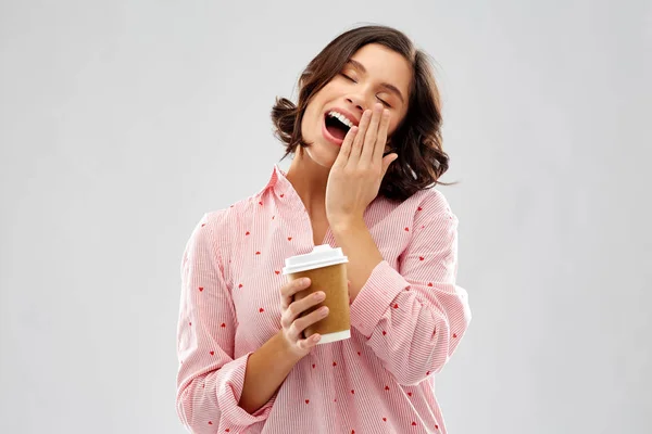 Felice giovane donna in pigiama con una tazza di caffè — Foto Stock