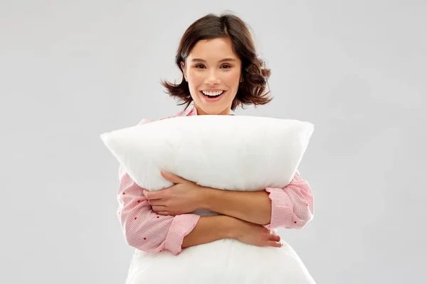 Szczęśliwa młoda kobieta w piżamę przytulanie poduszkę — Zdjęcie stockowe