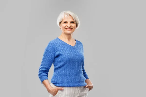 Portret van lachende senior vrouw in blauwe trui — Stockfoto