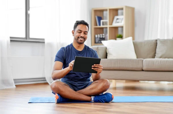 Uomo indiano con tablet pc e tappetino per esercizi a casa — Foto Stock