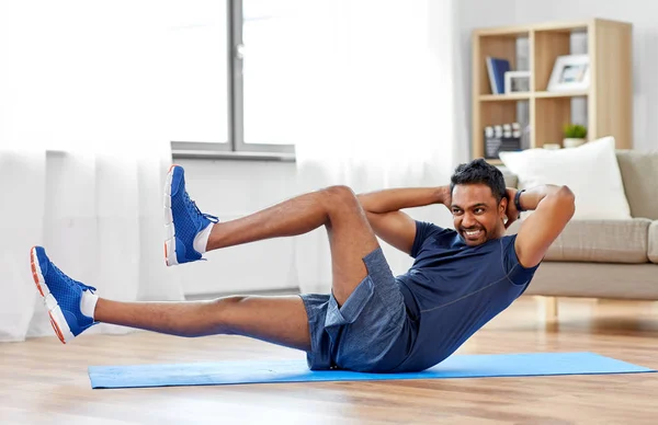 Homem indiano fazendo exercícios abdominais em casa — Fotografia de Stock