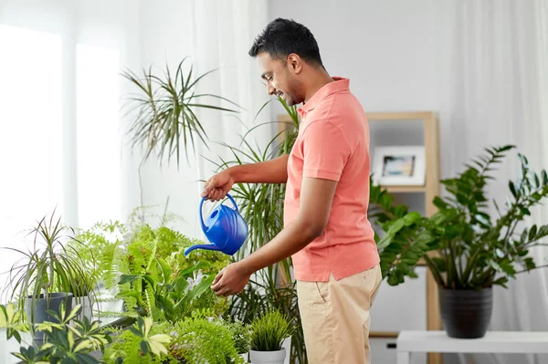 Hombre indio regando plantas de interior en casa — Foto de Stock