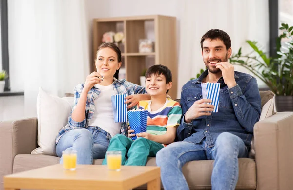 Famiglia felice con popcorn guardando la tv a casa — Foto Stock