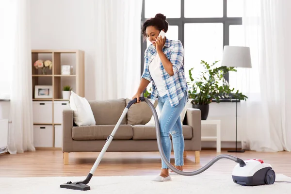 African american woman with vacuum cleaner at home — Stock Photo, Image