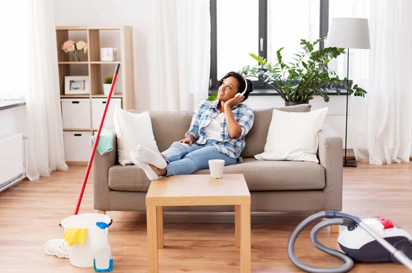 Mujer en auriculares descansando después de la limpieza del hogar — Foto de Stock