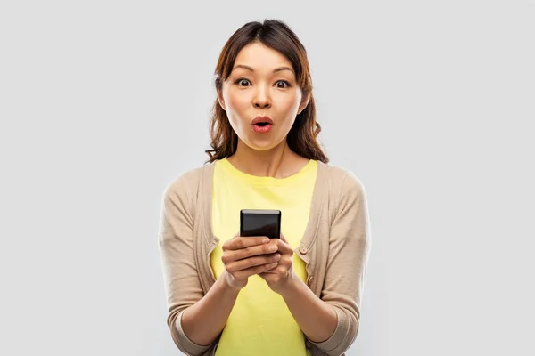 Удивленный азиатская женщина с помощью смартфона — стоковое фото