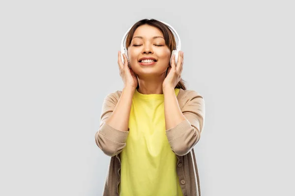 Asian woman in headphones listening to music — Stock Photo, Image