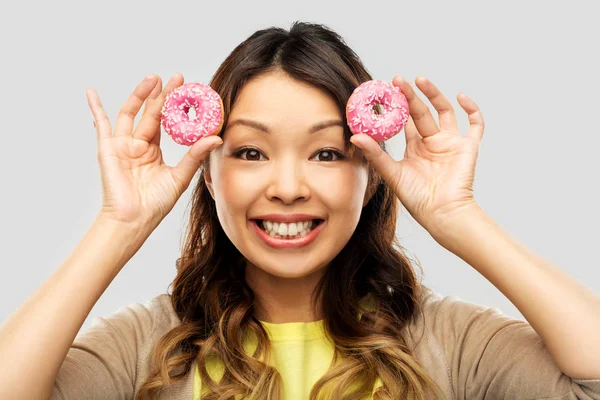 Happy asian woman with donuts — Stock Photo, Image