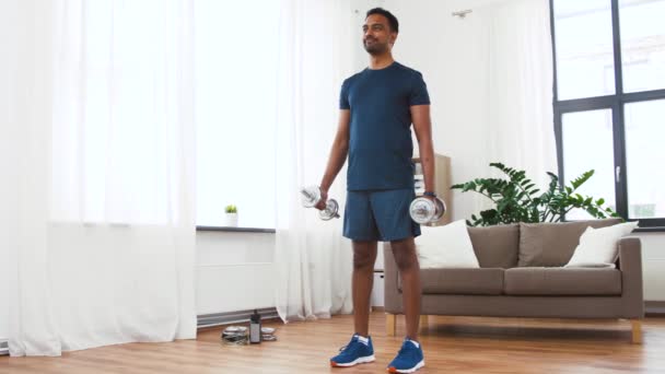 Indian man exercising with dumbbells at home — Stock Video