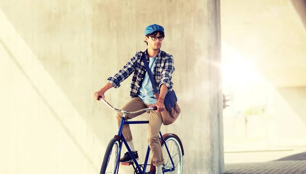 Junger Hipster-Mann mit Tasche fährt Fahrrad mit festem Gang — Stockfoto