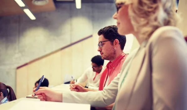 Studentengruppe mit Notizbüchern im Hörsaal — Stockfoto