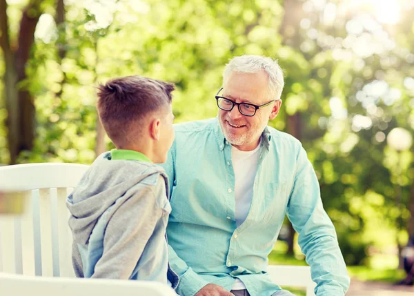 Дедушка и внук разговаривают в летнем парке — стоковое фото