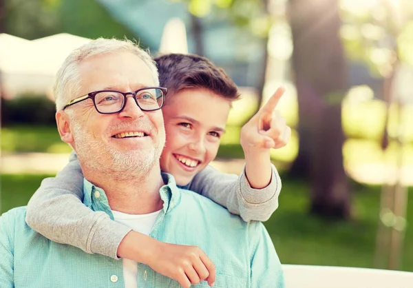 Grandfather and boy pointing finger at summer park — Stock Photo, Image