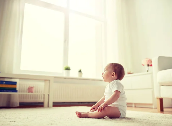 Niño o niña feliz sentado en el suelo en casa — Foto de Stock