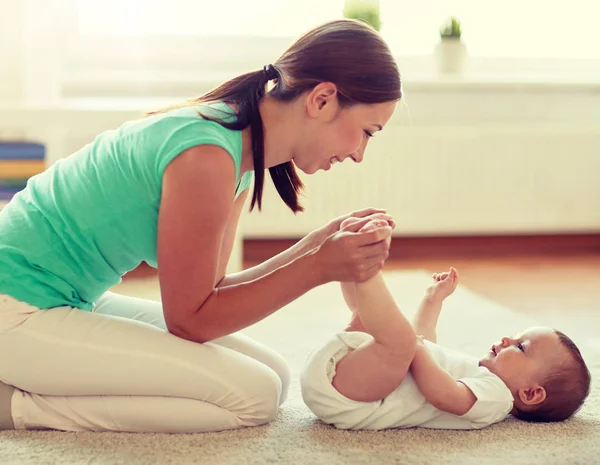 Mãe feliz brincando com o bebê em casa — Fotografia de Stock