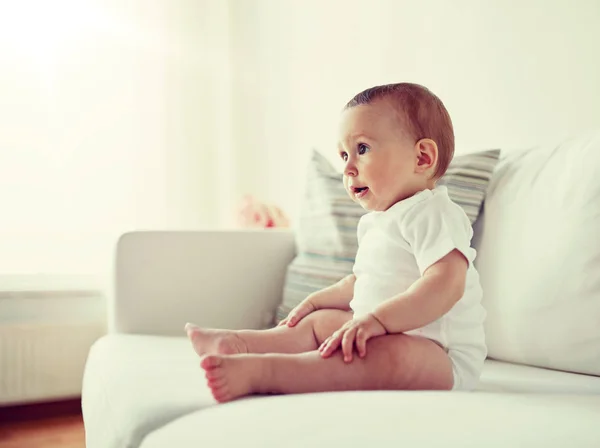 Niño o niña feliz sentado en el sofá en casa —  Fotos de Stock