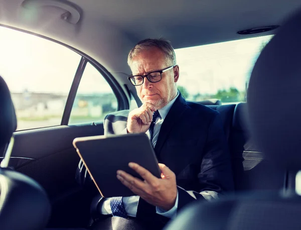 Hombre de negocios senior con la PC tableta de conducción en el coche —  Fotos de Stock