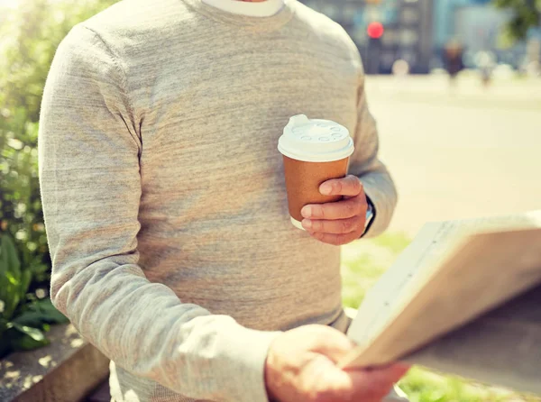 Senior man with coffee reading newspaper outdoors — Stock Photo, Image