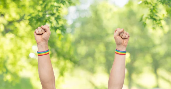 Hands with gay pride rainbow wristbands shows fist — Stock Photo, Image