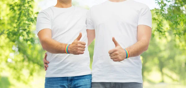 Para gejów z rainbow opaski pokazuje kciuk w — Zdjęcie stockowe
