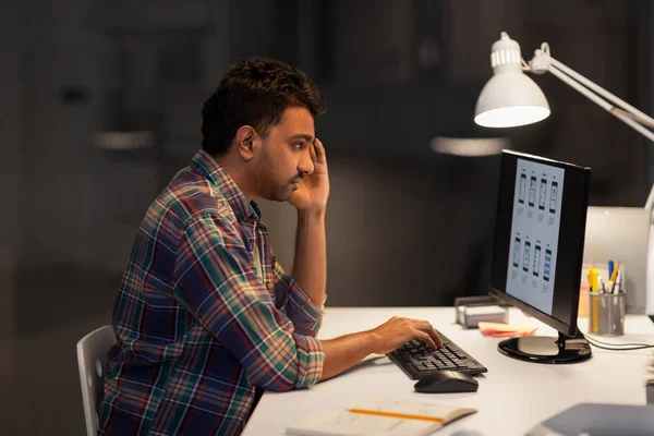 Homme créatif avec ordinateur travaillant au bureau de nuit — Photo