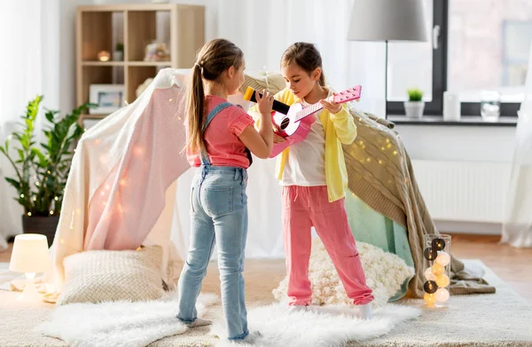 Meninas com guitarra e microfone jogando em casa — Fotografia de Stock