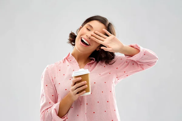 Felice giovane donna in pigiama con una tazza di caffè — Foto Stock