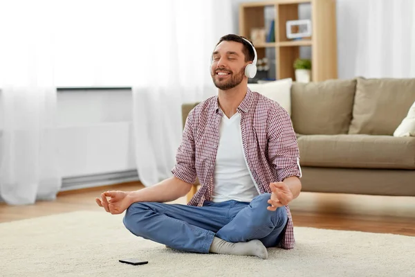 Homem em fones de ouvido meditando ouvir música — Fotografia de Stock