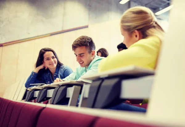 Skupina studentů se zápisníky v přednáškovém sále — Stock fotografie