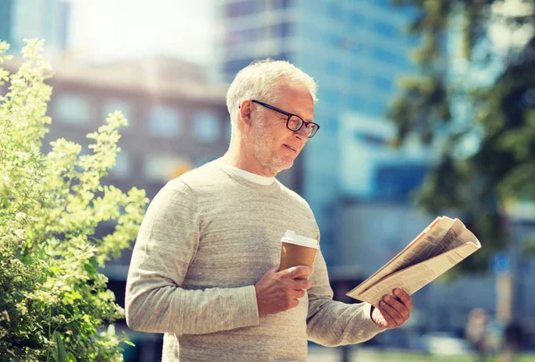 Senior man läsa tidningen och dricka kaffe — Stockfoto